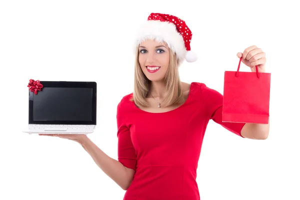 Mulher feliz no chapéu de Papai Noel segurando o notebook e agora sobre o branco — Fotografia de Stock