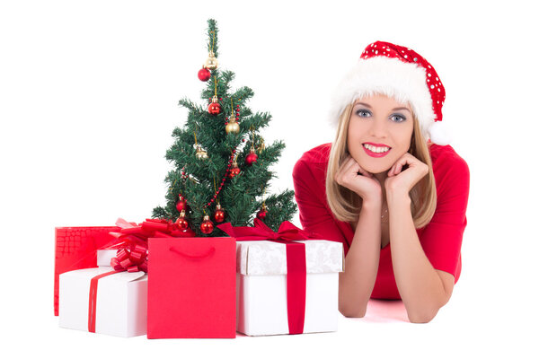 Young woman lying down with christmas tree and gifts isolated on