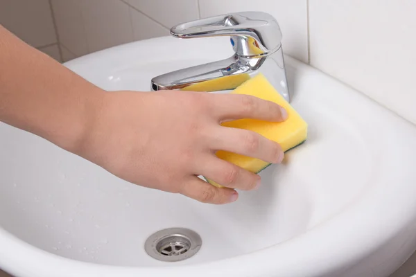 Male hand with sponge cleaning sink — Stock Photo, Image