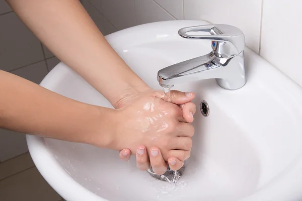 Homem lavando as mãos no lavatório do banheiro — Fotografia de Stock