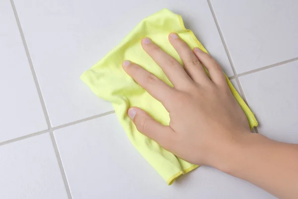 Hand with rag cleaning tile wall — Stock Photo, Image