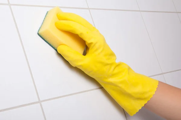 Hand in glove cleaning tile wall — Stock Photo, Image