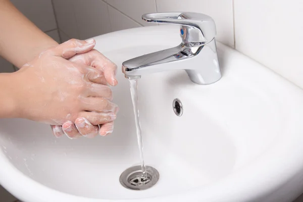 Homem lavando as mãos no lavatório do banheiro — Fotografia de Stock