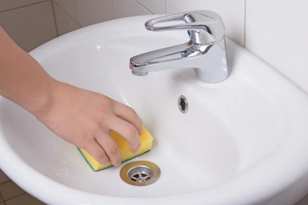 Mão masculino com amarelo esponja de limpeza da pia — Fotografia de Stock