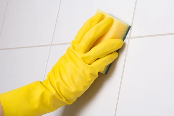 Hand in glove cleaning tile wall