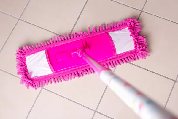 Pink mop cleaning tile floor in bathroom — Stock Photo, Image