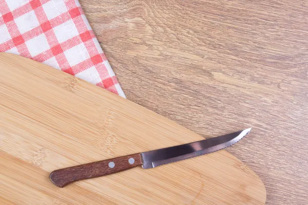 Nóż na drewnianym stole z obrus w kratkę — Zdjęcie stockowe