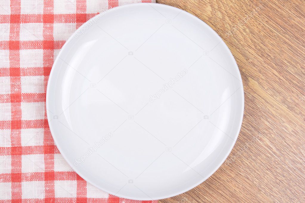 empty plate on the wooden table with checkered tablecloth