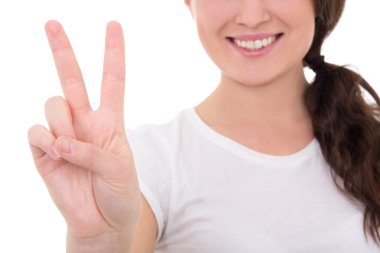 Barış üzerine beyaz izole işareti veren genç gülümseyen kadın