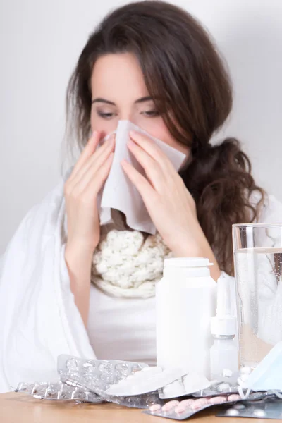 Ill woman blowing her nose in her living room — Stock Photo, Image