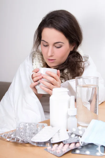 Kranke Frau trinken Tee in ihrem Wohnzimmer — Stockfoto