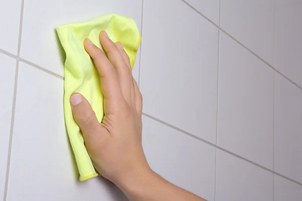 Mano con straccio, pulire le piastrelle del bagno — Foto Stock