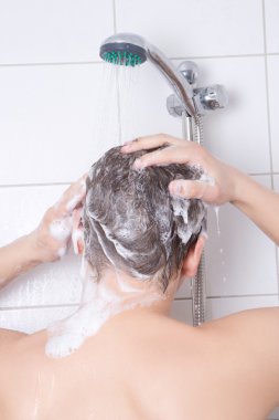 arkadan görünüşü saç şampuanla yıkamak çekici genç bir adam