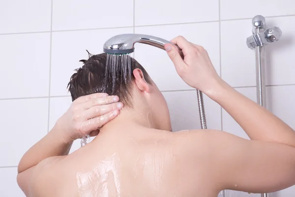 Bakifrån av ung man med en dusch — Stock fotografie