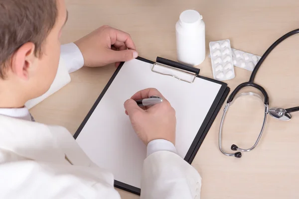 Male doctor prescribing treatment in modern office — Stock Photo, Image