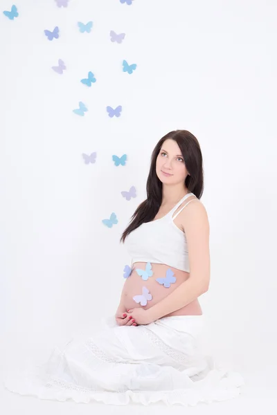 Joven embarazada con coloridas mariposas en el vientre —  Fotos de Stock