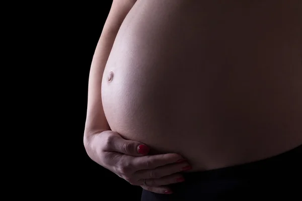 Barriga de mulher grávida isolada no preto — Fotografia de Stock