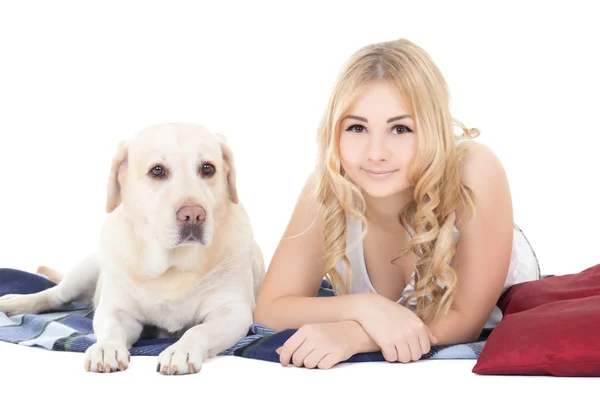 Jonge mooie blonde in pyjama's liggend met hond geïsoleerd op whit — Stockfoto