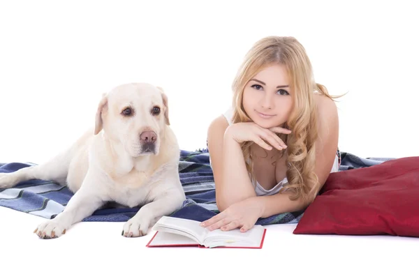Ung vacker blond i pyjamas liggande med bok och hund isolera — Stockfoto