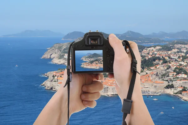 Photocamera in male hands taking picture of beautiful landscape — Stock Photo, Image