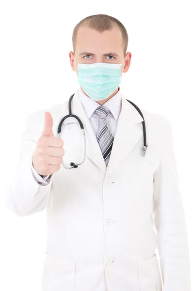 Portret van de jonge dokter in masker duimschroef opwaarts geïsoleerd op wit — Stockfoto