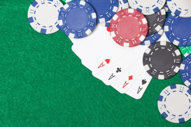 Poker fişleri ve iskambil yeşil tablo arka plan üzerinde
