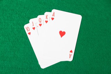 Poker kartları floş royal kombinasyon üzerinde yeşil bir bez ile