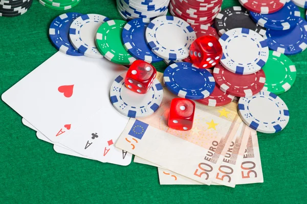 Kostky, čtyři esa, barevné poker žetony a euro bankovky na skupi — Stock fotografie