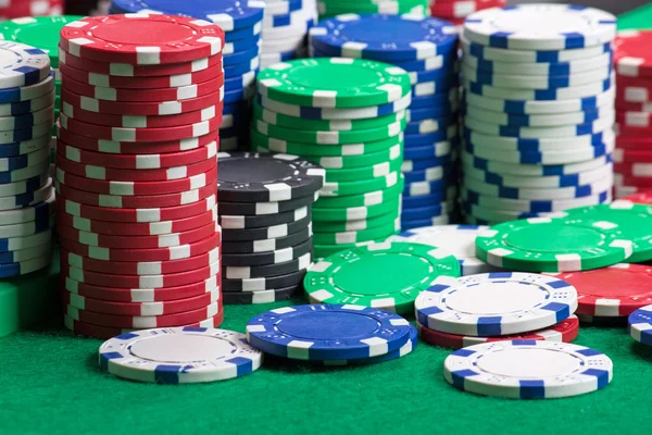 Fichas de pôquer colorido em um cassino verde sentiu — Fotografia de Stock