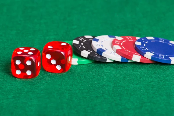 Fiches da poker colorato e dadi su un green in feltro — Foto Stock