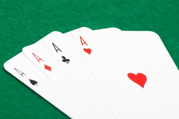 Playing cards - four aces on green table — Stock Photo, Image