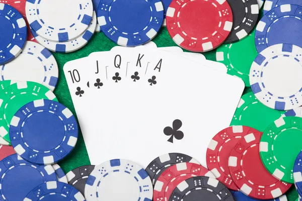 Close-up de uma combinação de royal flush no poker com chips sobre o — Fotografia de Stock