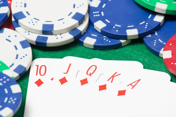 Combinazione di scala reale a poker con fiches sul tavolo verde — Foto Stock