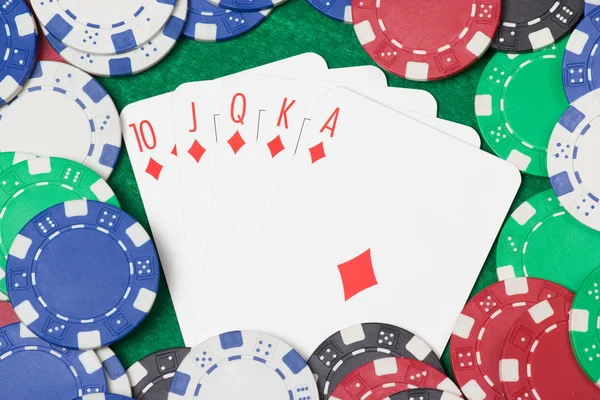 皇家同花顺组合和扑克筹码在绿色的桌子上 — 图库照片
