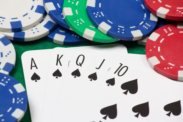 在绿色选项卡上玩扑克筹码和皇家同花顺组合 — 图库照片
