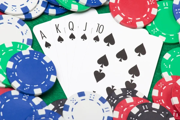 Poker chips and royal flush combination at poker on the green ta — Stock Photo, Image