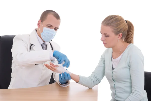 Young doctor bandaging female hand isolated on white — Stock Photo, Image