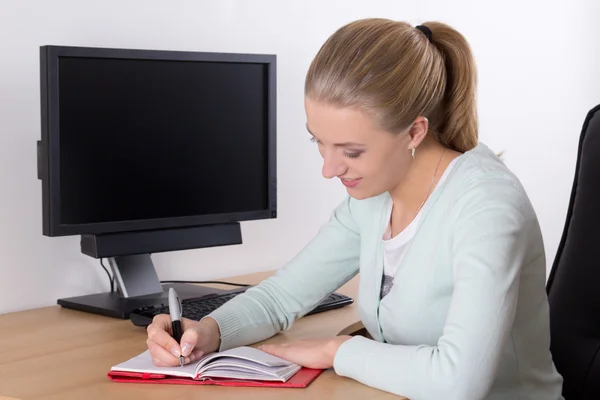 Young blondie woman writing in notebook Royalty Free Stock Images