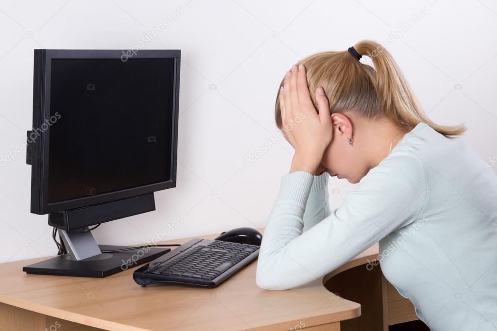 back view of stressed woman with personal computer at work