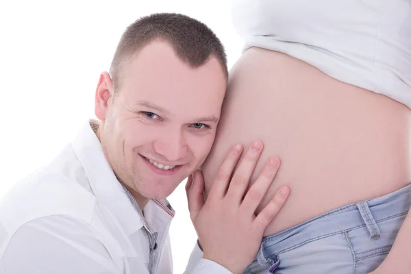年轻人听他怀孕的妻子的肚子 — 图库照片