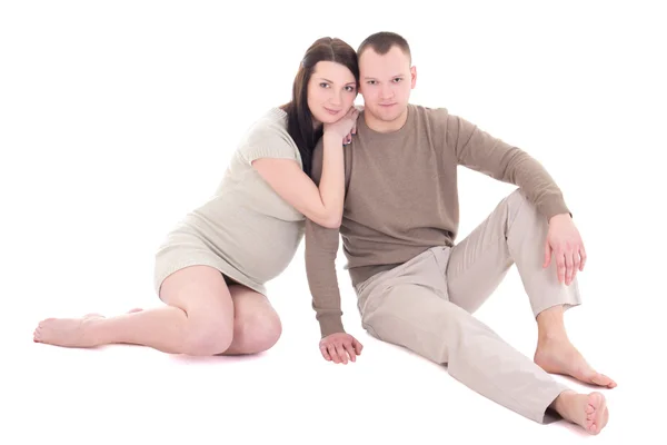 Молодая беременная пара сидя, изолированные на белом фоне — стоковое фото