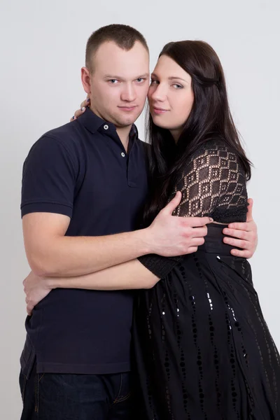 Young beautiful pregnant woman and her husband over grey — Stock Photo, Image