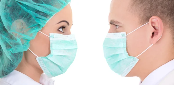 Young male and female surgeons in protective masks isolated on w — Stock Photo, Image