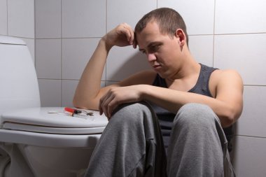 Tuvalette otururken eroin bağımlılığı ile depresif adam