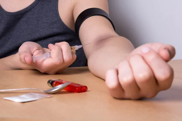 Cerca de drogadicto inyectándose heroína a su mano con jeringa — Foto de Stock