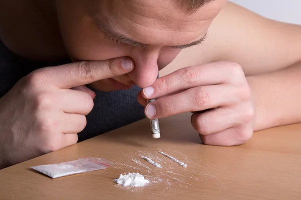 Verslaafde snuiven heroïne uit de tabel — Stockfoto