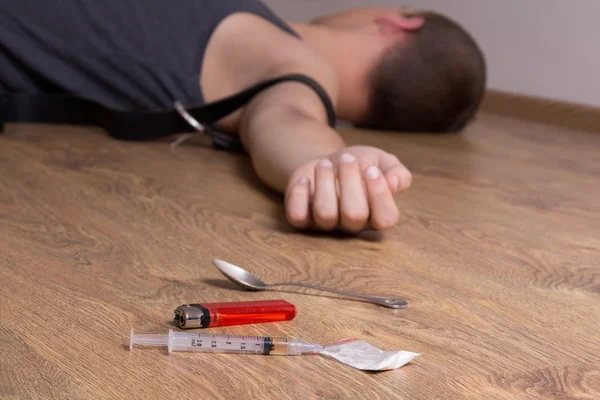 Drugs op de vloer en gestenigd verslaafde — Stockfoto