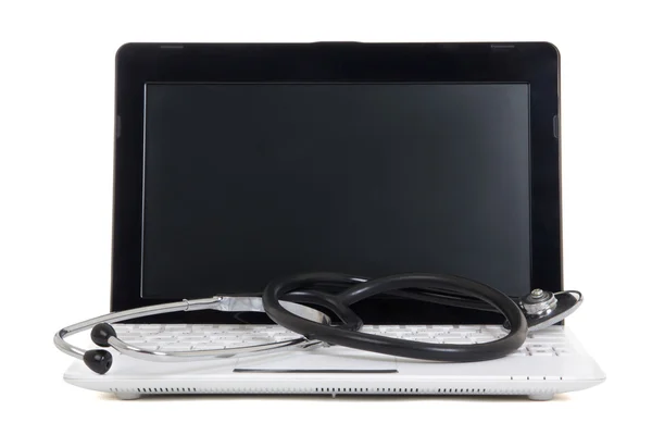 Pequeño ordenador portátil con pantalla en blanco y un estetoscopio aislado en Pentecostés —  Fotos de Stock