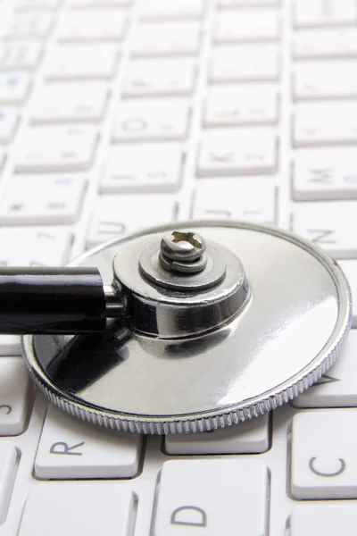 Close up of stethoscope on white laptop keyboard — Stock Photo, Image