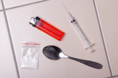 ilaç şırınga, eroin tozu paketi, kaşık ve çakmak üzerinde